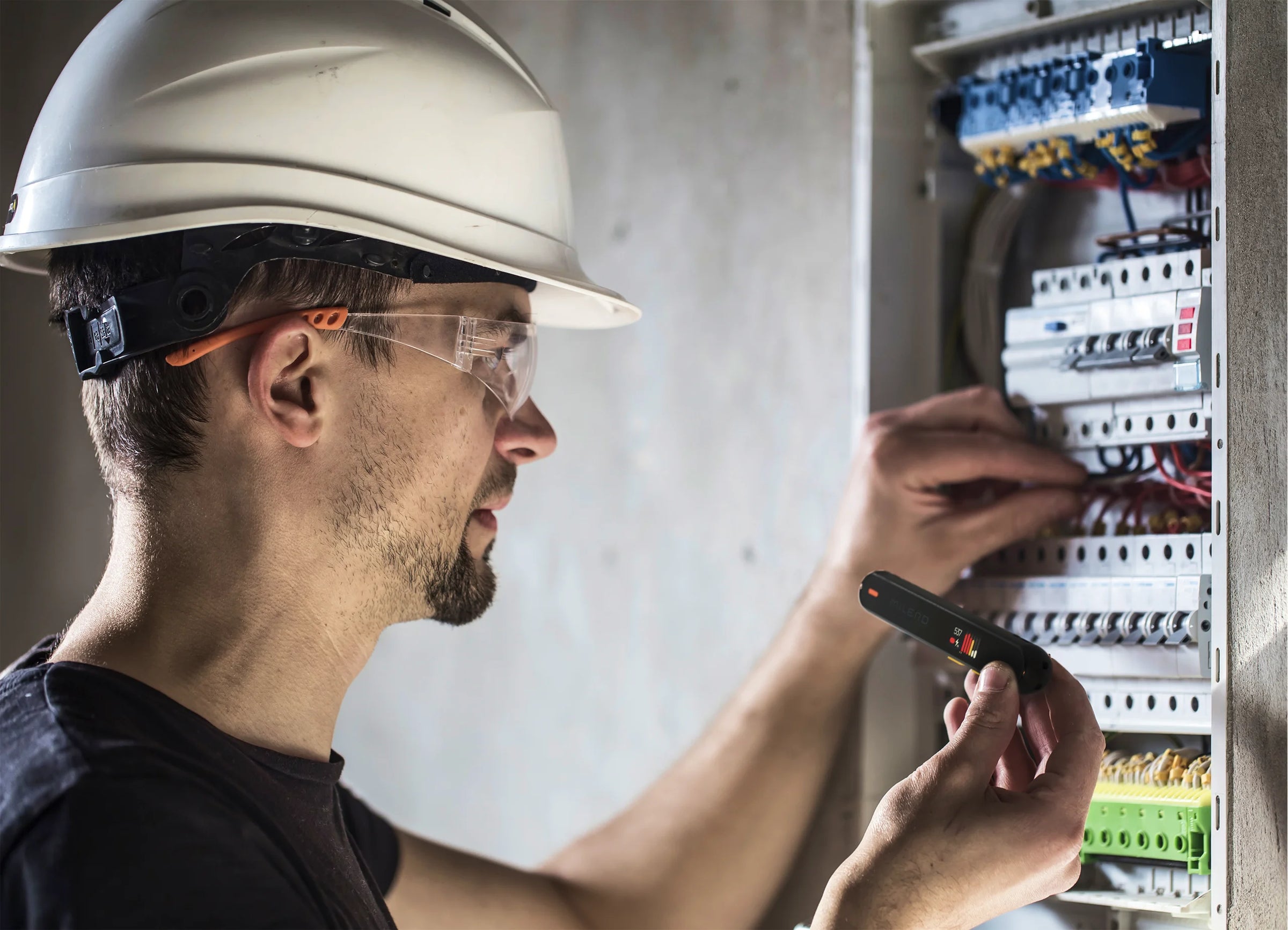 A man checks the wires with an emf detector